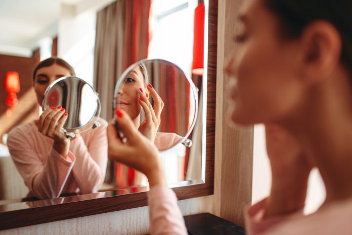 woman-doing-makeup-at-the-mirror-face-hygiene-R25DH6N (1)1562587539912