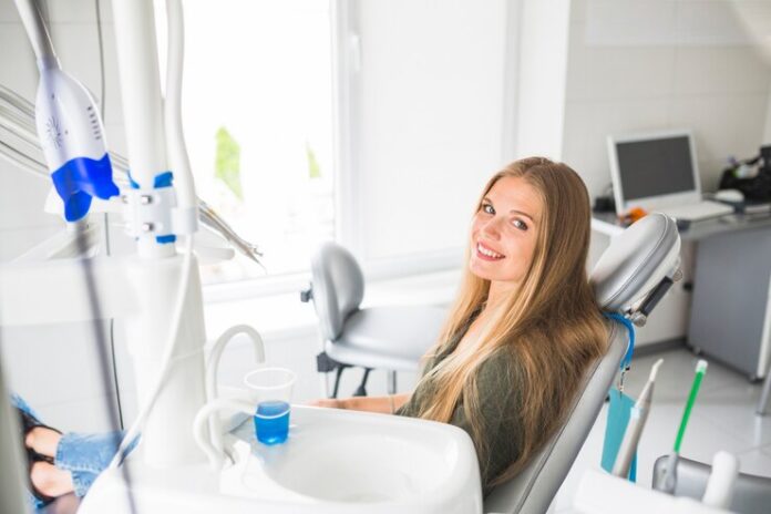 happy-young-woman-sitting-dental-chair_23-2147862029