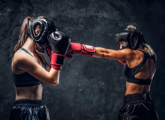 process-fight-two-female-boxers-gloves-helmets-dark-background_613910-12568